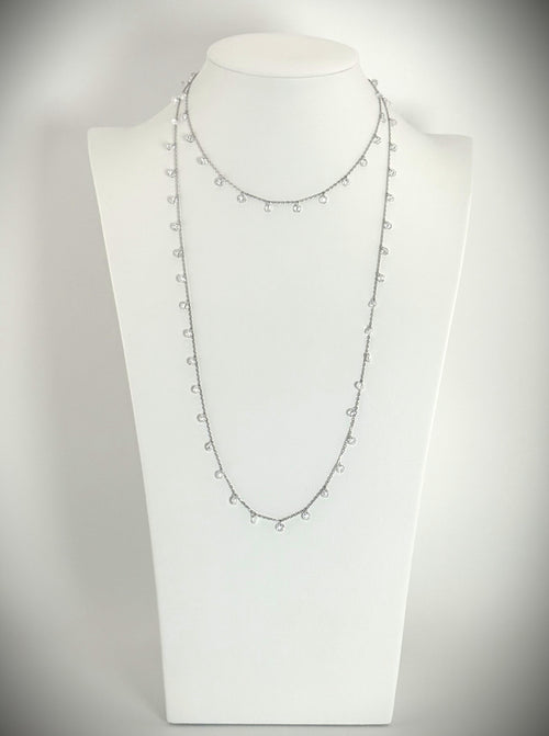 Silver necklace with a string of diamonds on a mannequin bust against a white background