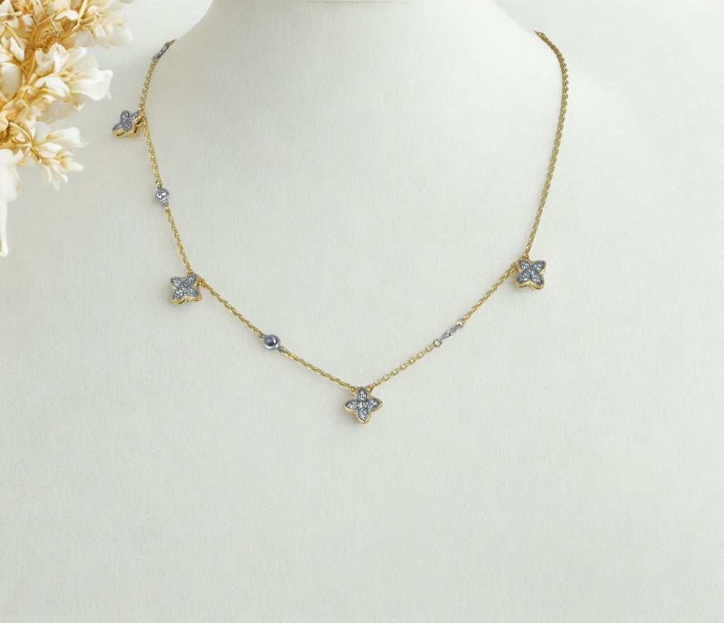 Elegant gold clover necklace featuring diamond-accent charms on a fine chain