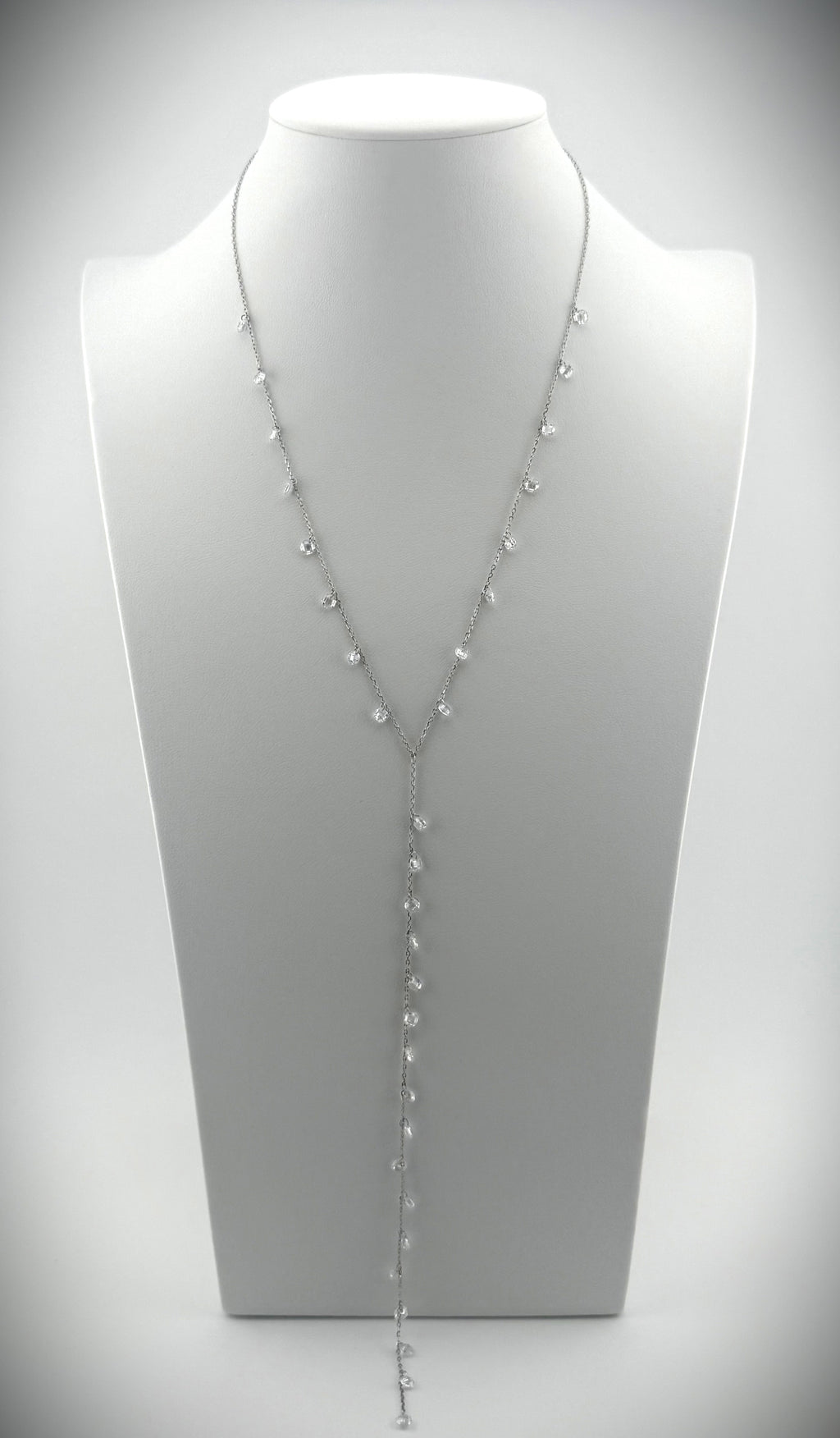 Elegant silver Y-necklace featuring cascading diamond details, styled on a minimalist white bust.