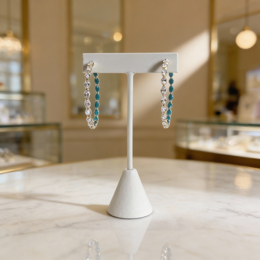 Elegant silver diamond and turquoise earrings showcased on a marble surface with soft, refined lighting.