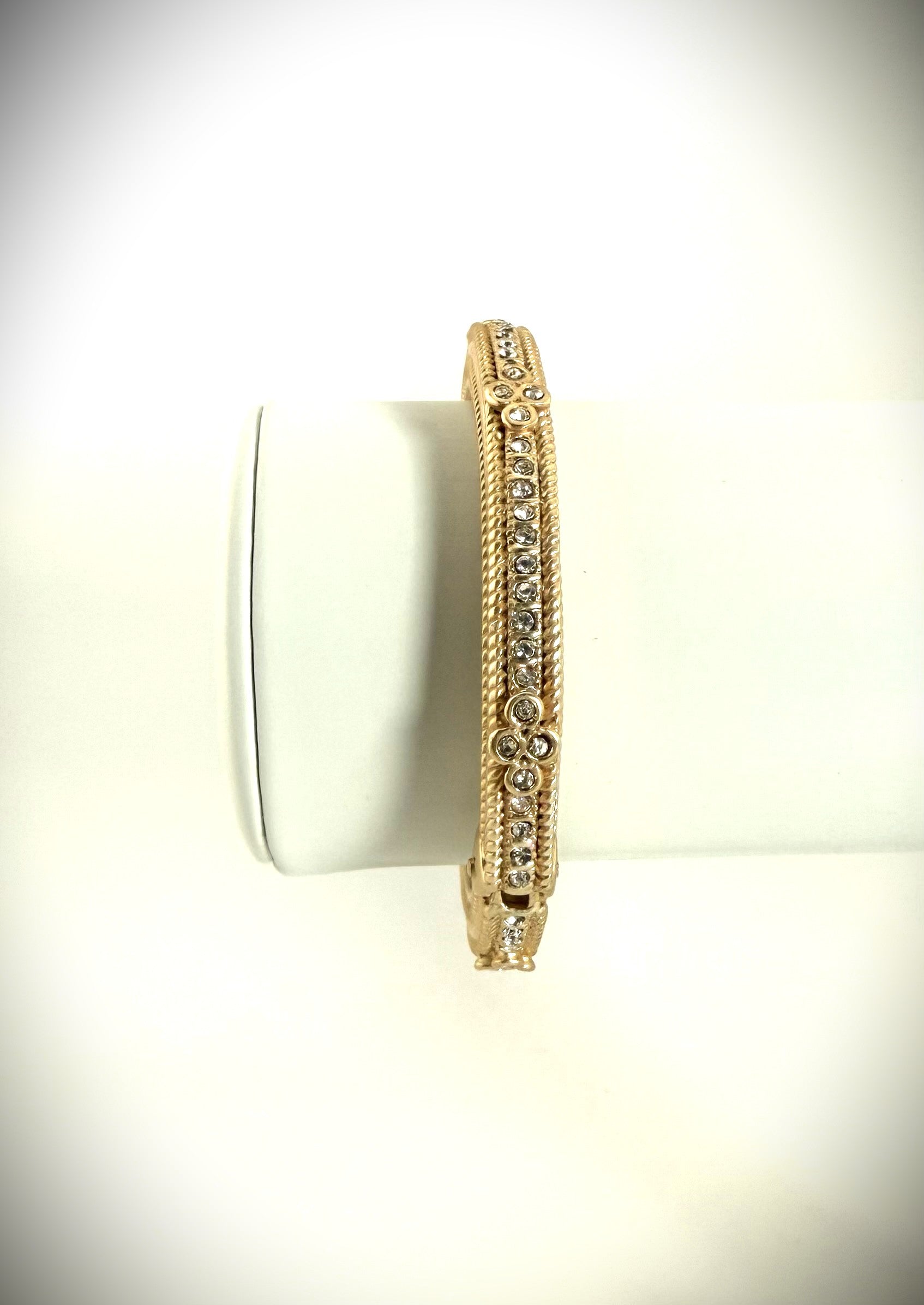 Gold bracelet with diamond accents on a white background