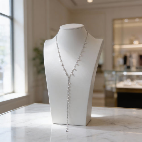 Silver Y-shaped diamond necklace displayed on a white jewelry bust.