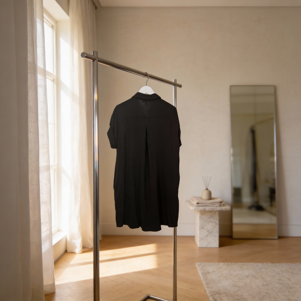 Women’s black short sleeve button-up woven shirt dress featuring a relaxed silhouette and center back pleat.