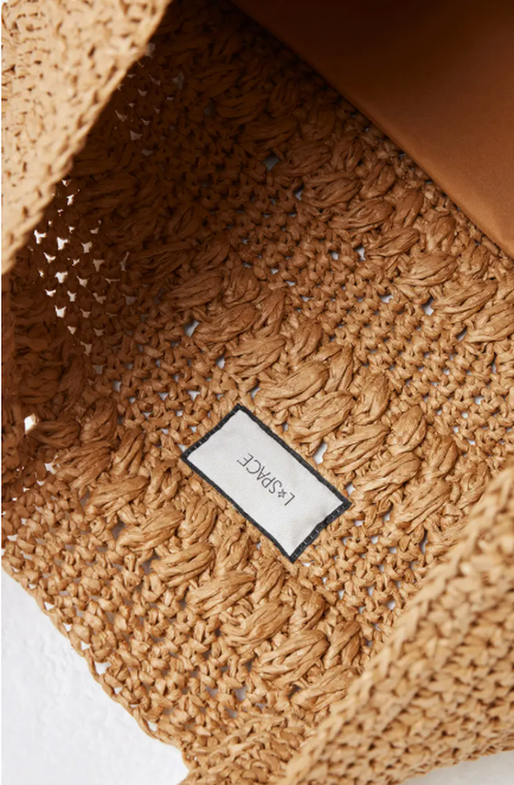 Close-up of a textured brown bag with a visible brand label.