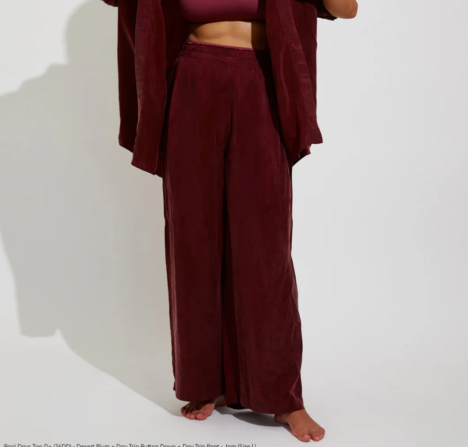 Person wearing a burgundy outfit with a top and wide-leg pants on a white background