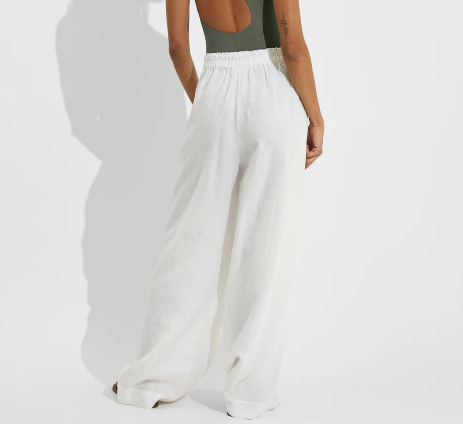 White wide-leg coastal pants with elastic waistband, shown from the back on model