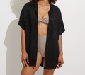 Black short-sleeve button-down shirt styled open over swimwear