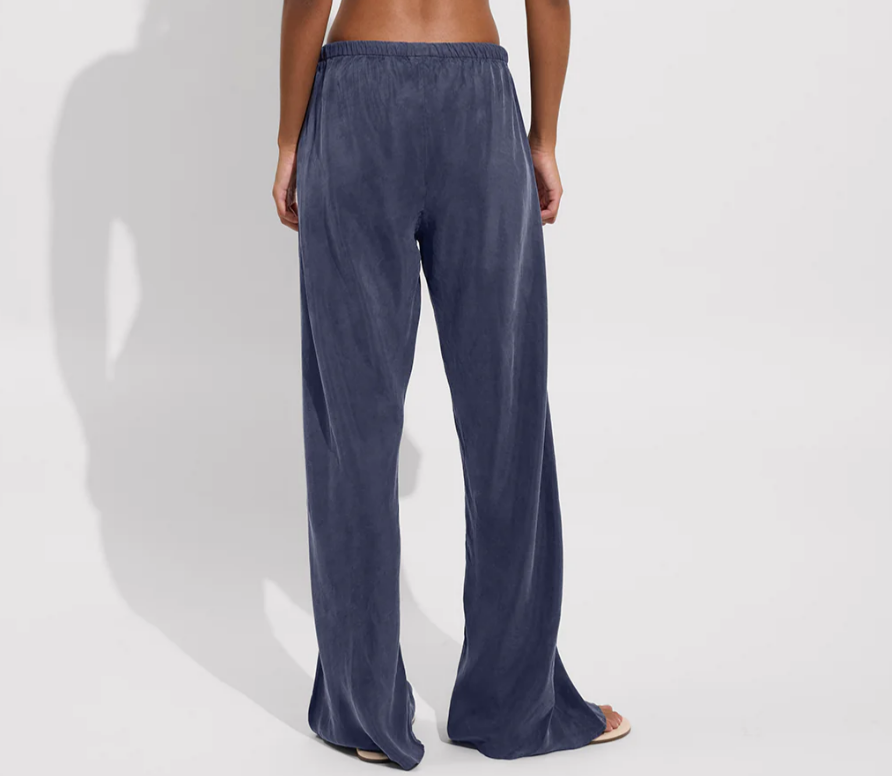 Person wearing blue wide-leg pants with drawstring on a white background