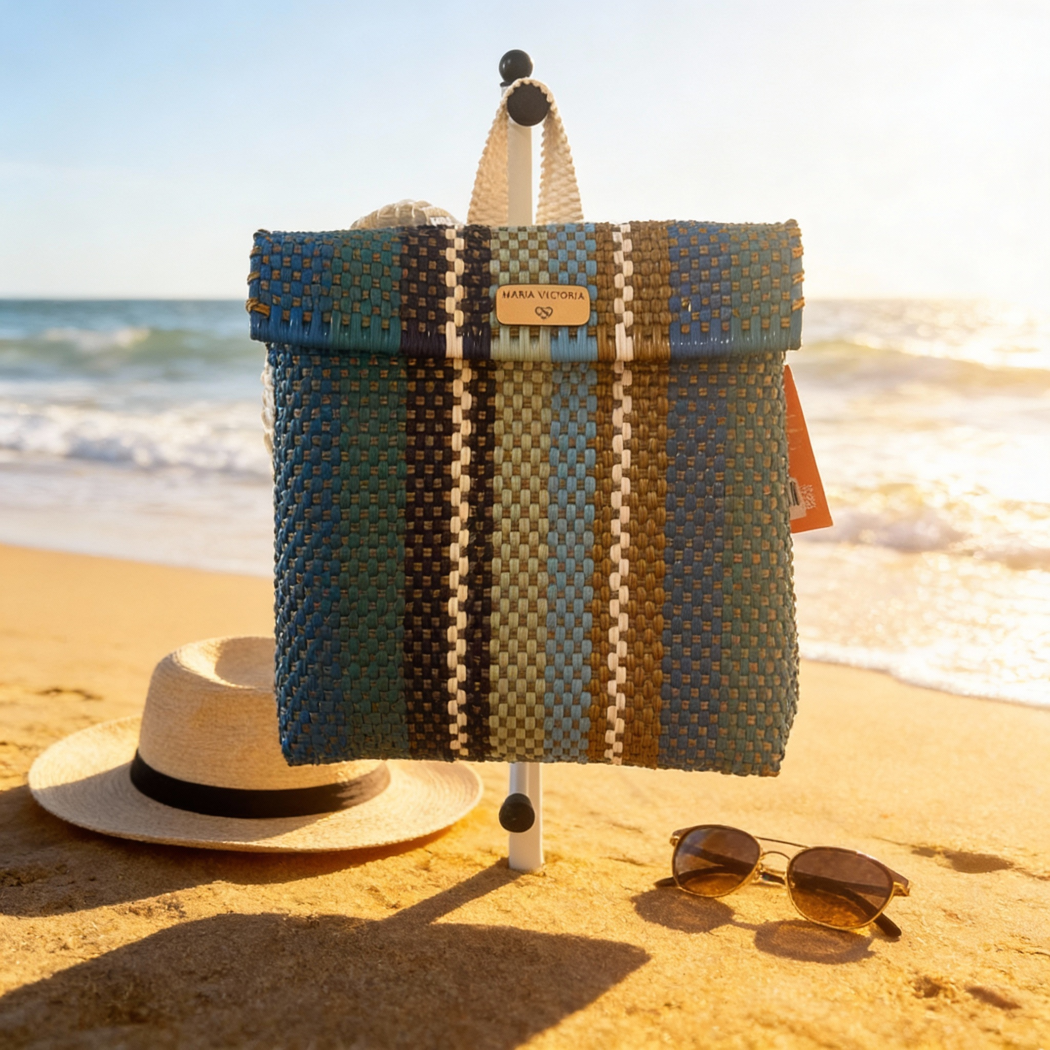 Colorful handwoven Maria Victoria “Billy Jeans” backpack featuring vibrant geometric patterns, leather top handle, adjustable straps, and front buckle closure
