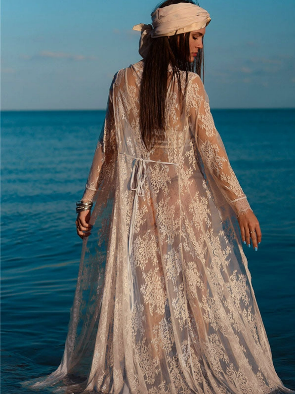 Sheer lace maxi beach cover-up worn by model standing in the ocean