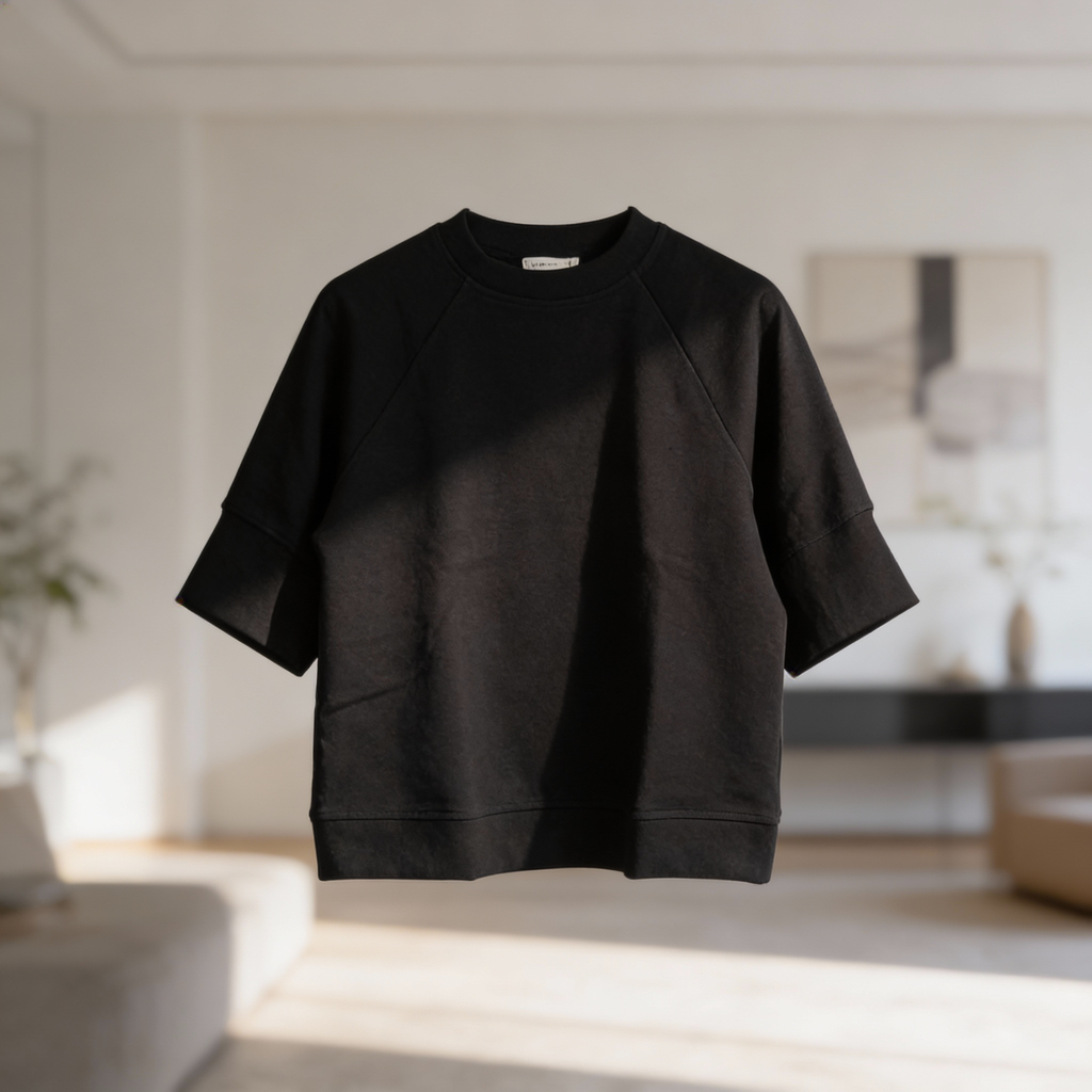 Black scuba knit short sleeve top with relaxed fit and crew neckline displayed on hanger