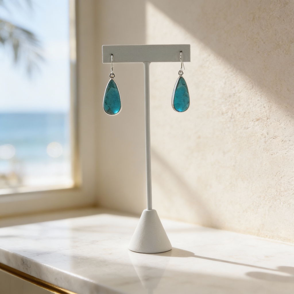 Sterling silver azure water drop earrings with turquoise teardrop stones on a minimalist display.