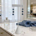 Sterling silver dangle earrings with blue aventurine stones displayed on a white jewelry stand.