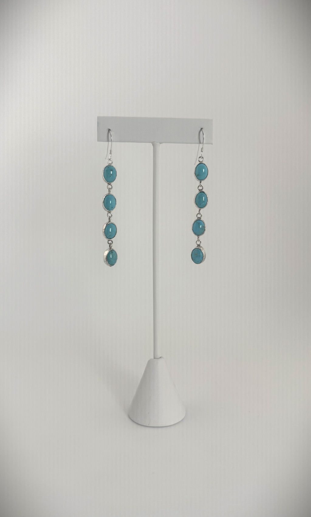 Handcrafted sterling silver drop earrings with multiple turquoise stones in a cascading design