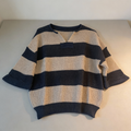 Women’s navy and tan striped V-neck sweater in a lightweight knit fabric, shown on a model wearing the top with jeans