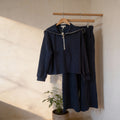Two-piece navy knit lounge set featuring a long-sleeve half-zip pullover with a sailor-style collar and matching wide-leg drawstring pants with elastic waistband and side pockets
