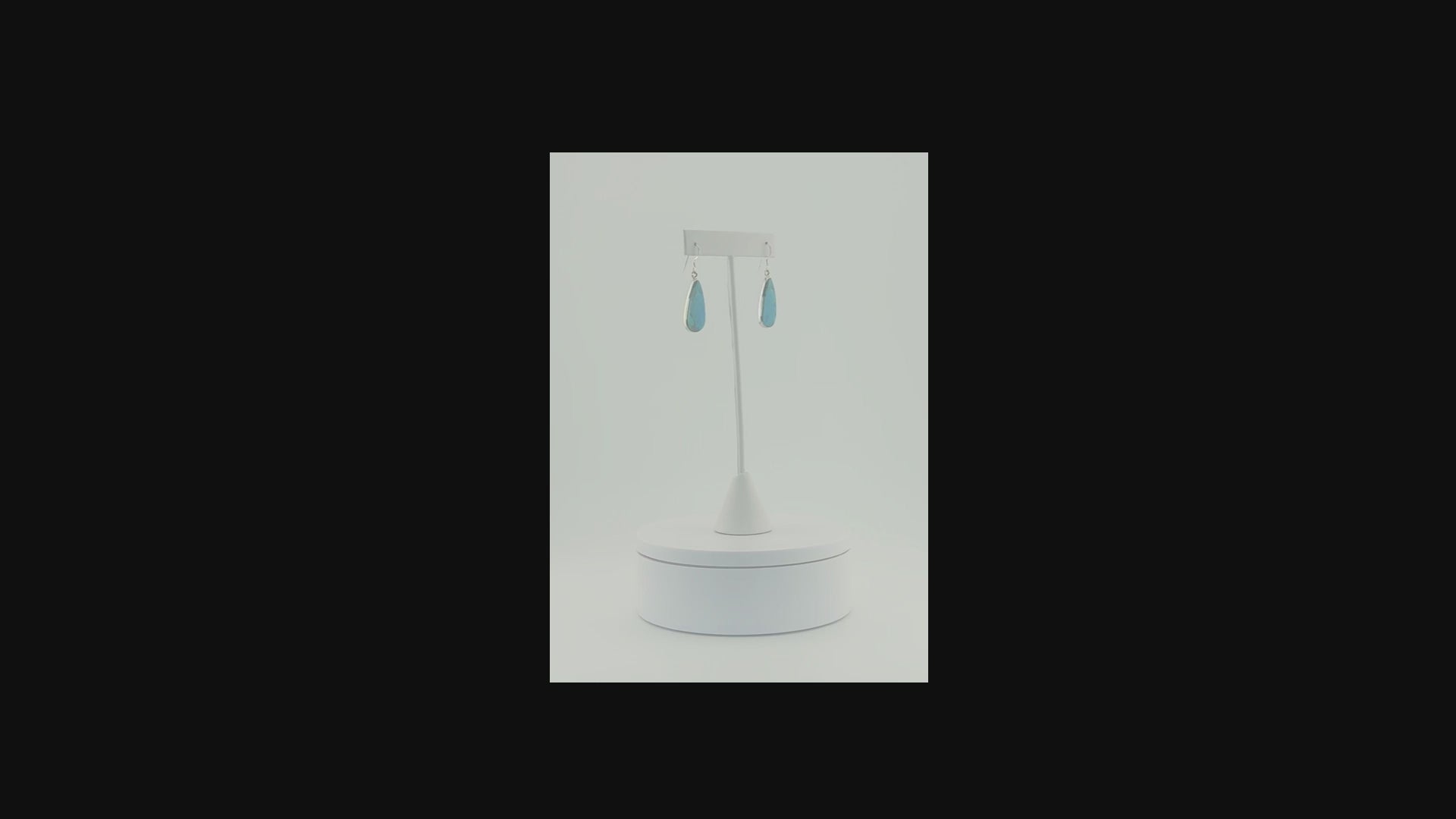 Sterling silver drop earrings featuring turquoise water drop stones video on a turning pedestal 